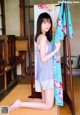 A woman sitting on the floor next to a towel rack.