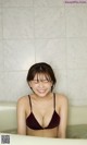 A woman in a bathtub smiling at the camera.